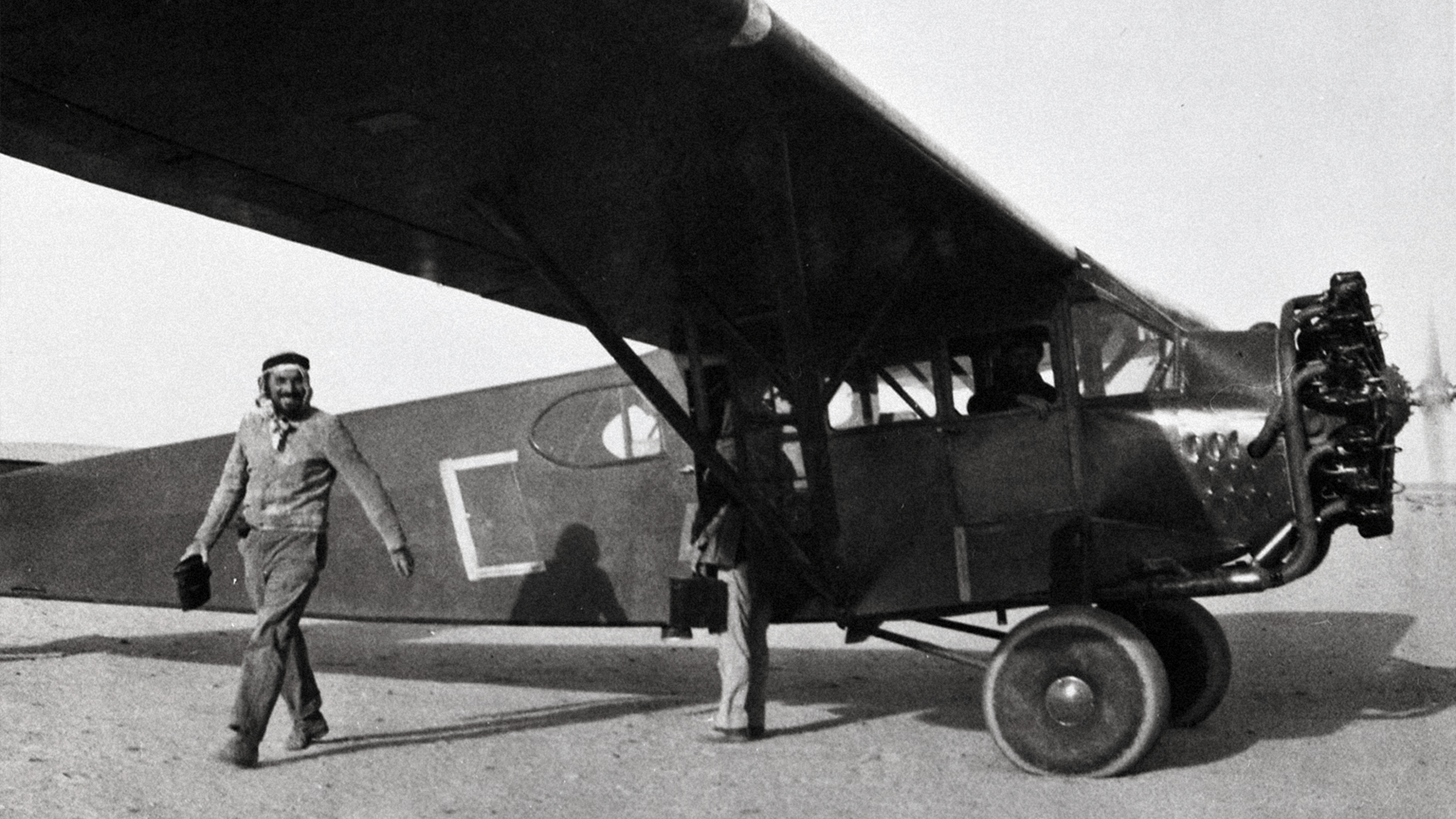 Person standing next to a Mukamalah airplane in the Saudi Arabian desert