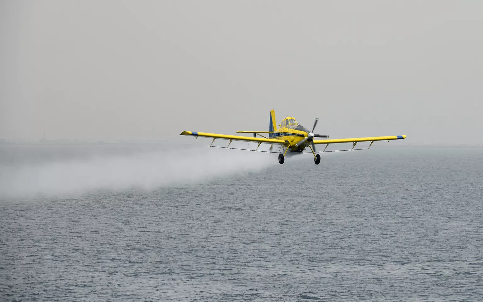 A Mukamalah airplane soaring through the sky with a misty trail flying over the Arabian ocean